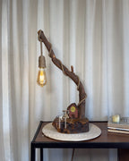 Red Hut Reach Lamp - Tall leaning branch with hanging light and cottage yar