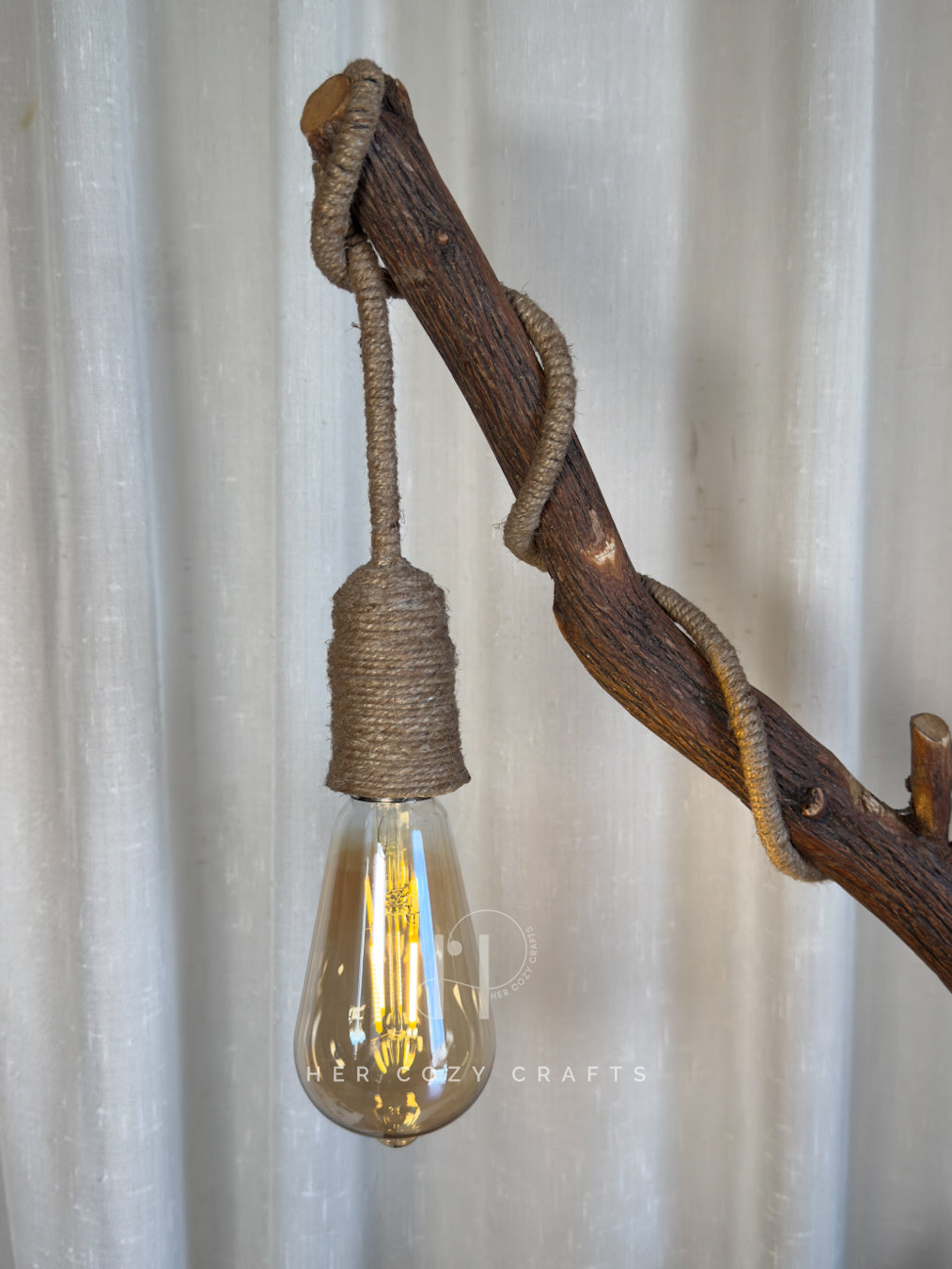 Red Hut Reach Lamp - Tall leaning branch with hanging light and cottage yar