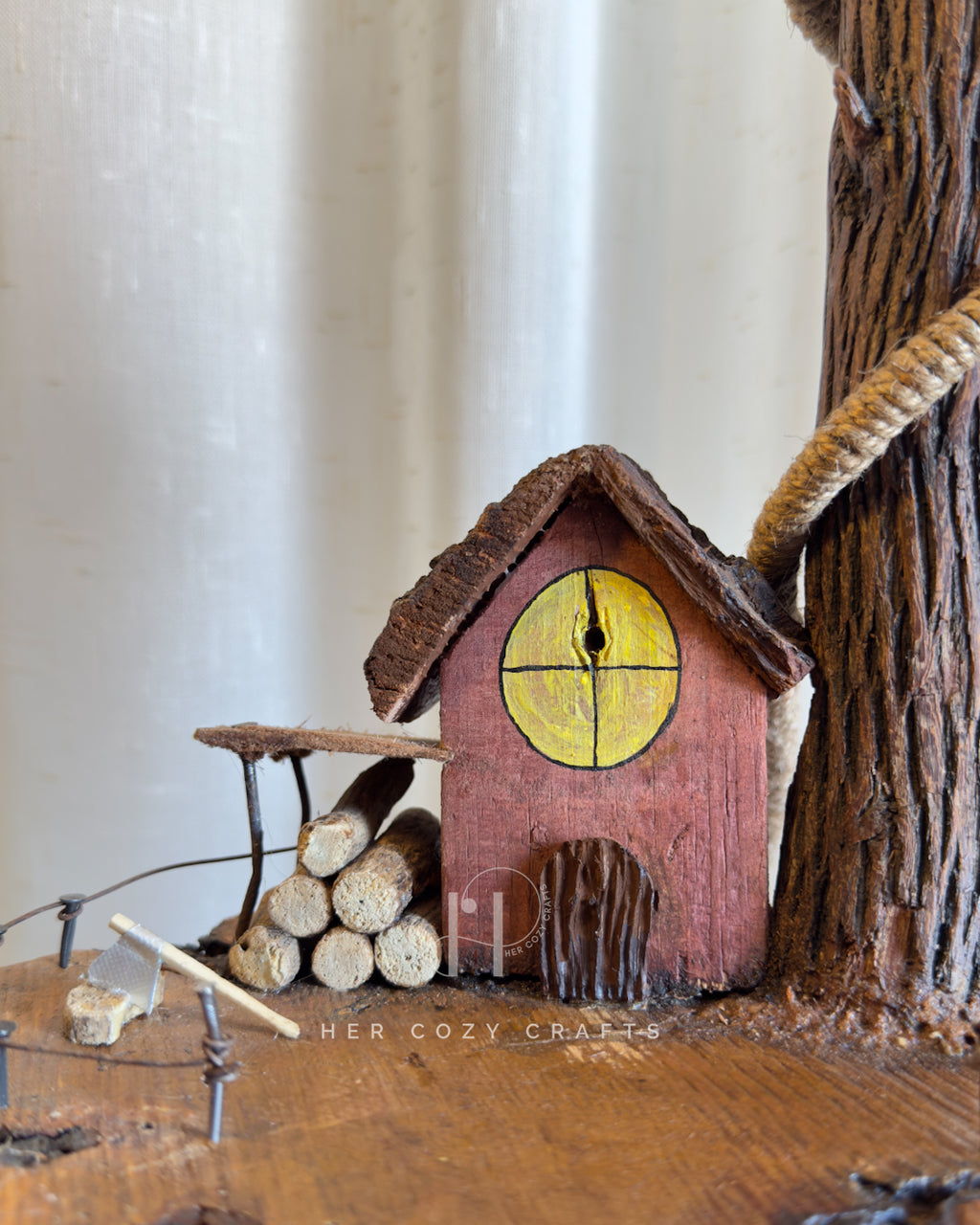 Red Hut Reach Lamp - Tall leaning branch with hanging light and cottage yar